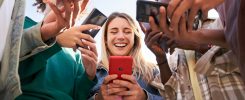 Low angle view of a group of young teenagers using cell phones. Concept of technology, connection.