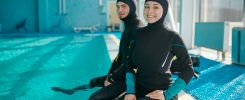 Woman and divemaster in scuba gear, diving school