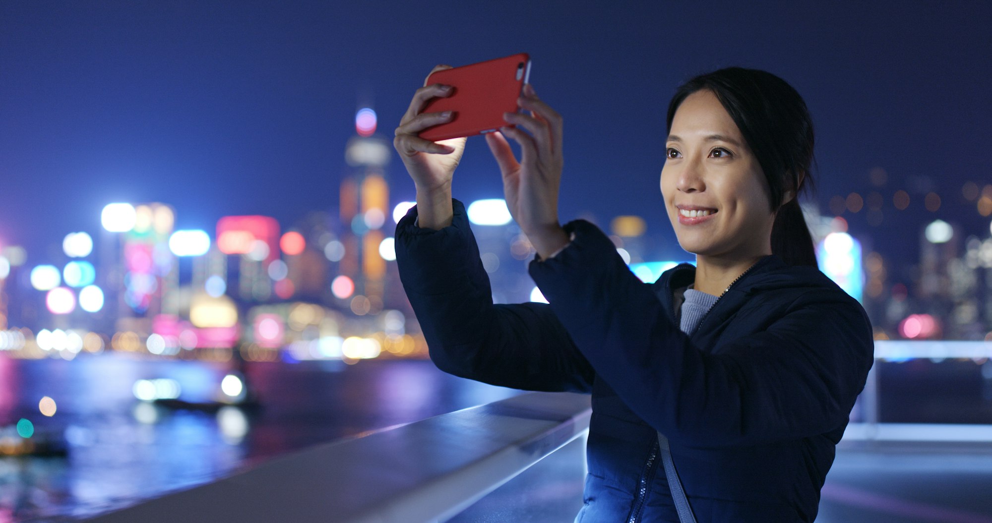 Woman take photo on cellphone at night
