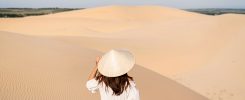 Young woman traveler enjoying at white sand dunes in Vietnam, Travel lifestyle concept