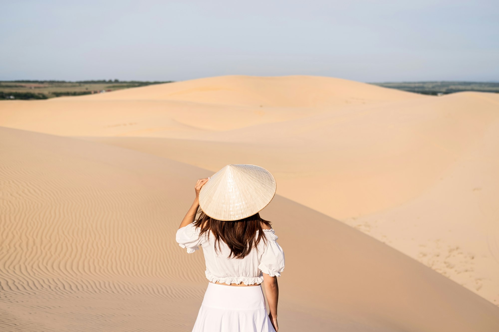 Young woman traveler enjoying at white sand dunes in Vietnam, Travel lifestyle concept